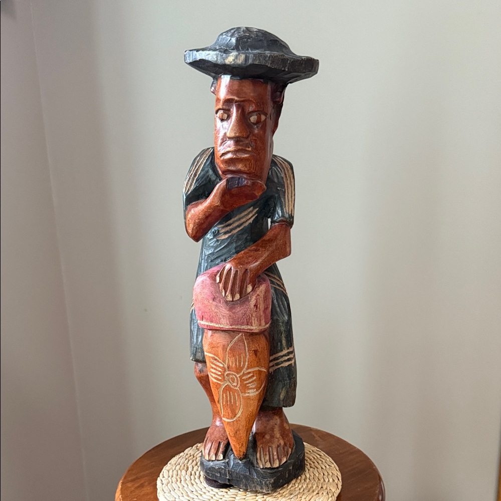 Wooden hand carved man playing bongo drum
